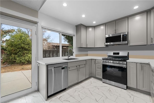 kitchen featuring appliances with stainless steel finishes, gray cabinetry, and sink