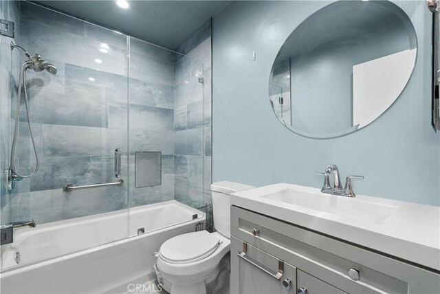 full bathroom with toilet, enclosed tub / shower combo, and vanity