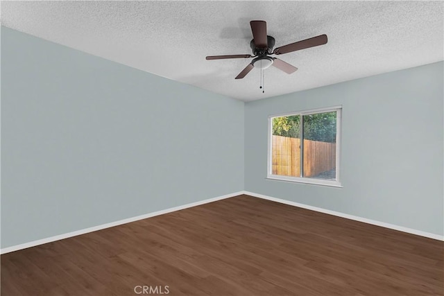 spare room with a textured ceiling, ceiling fan, and dark hardwood / wood-style floors