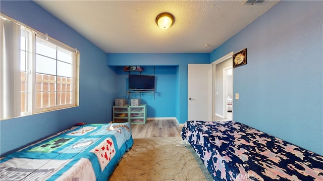 bedroom featuring a textured ceiling and light wood-type flooring