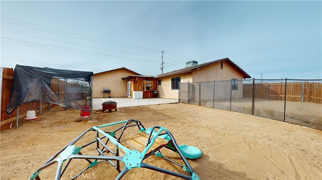 rear view of property featuring central AC unit and a patio area