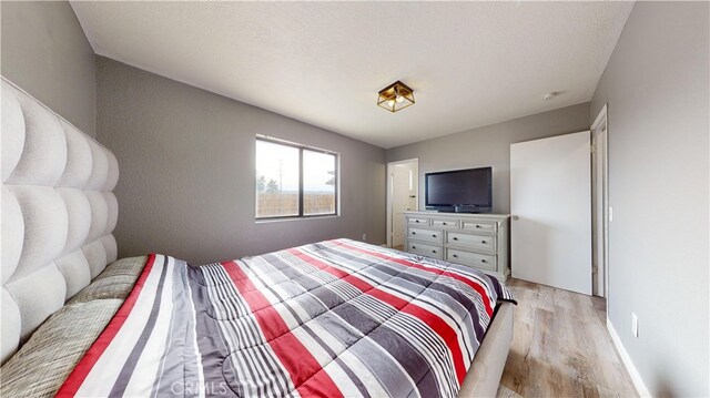 bedroom featuring light hardwood / wood-style floors and a textured ceiling