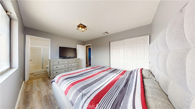 bedroom with light wood-type flooring, a closet, and connected bathroom