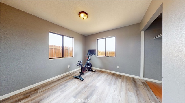 exercise room featuring light wood-type flooring