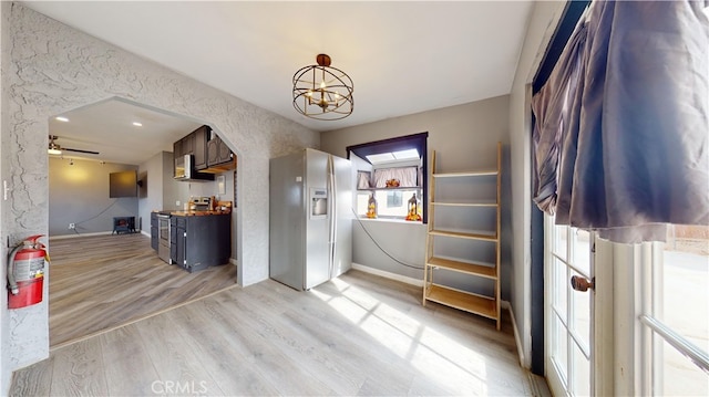 interior space with light hardwood / wood-style flooring and ceiling fan with notable chandelier