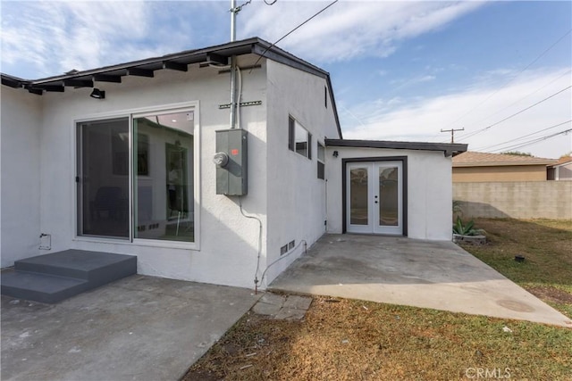 view of exterior entry with french doors and a patio area