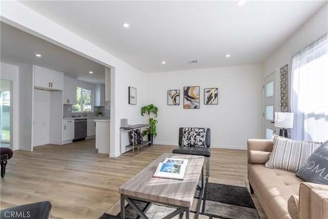 living room with sink and light hardwood / wood-style floors