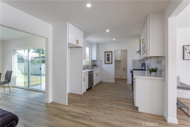 kitchen with white cabinets, a healthy amount of sunlight, light wood-type flooring, and appliances with stainless steel finishes