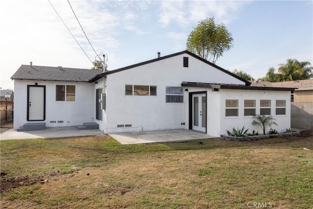 rear view of house featuring a patio area and a yard