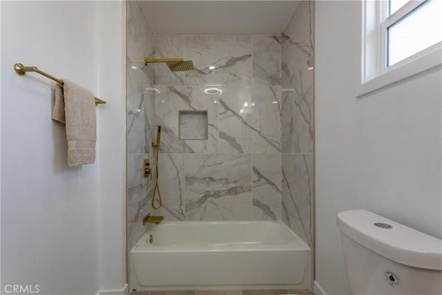 bathroom with toilet and tiled shower / bath