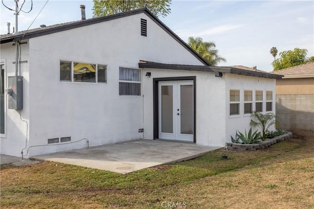 rear view of house featuring a yard, a patio, and french doors