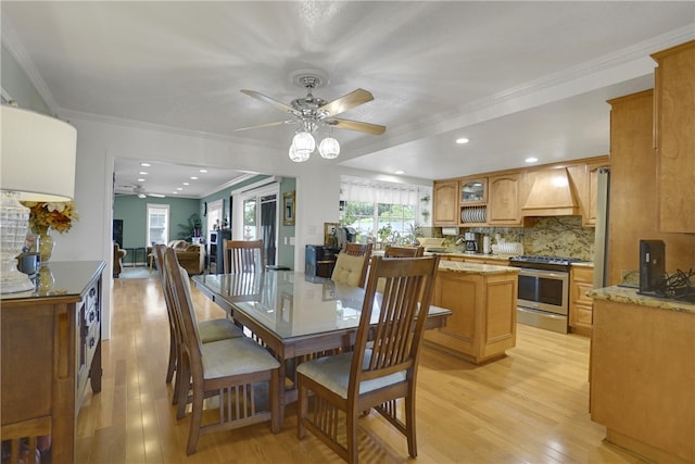 dining room featuring light hardwood / wood-style flooring, ceiling fan, and crown molding