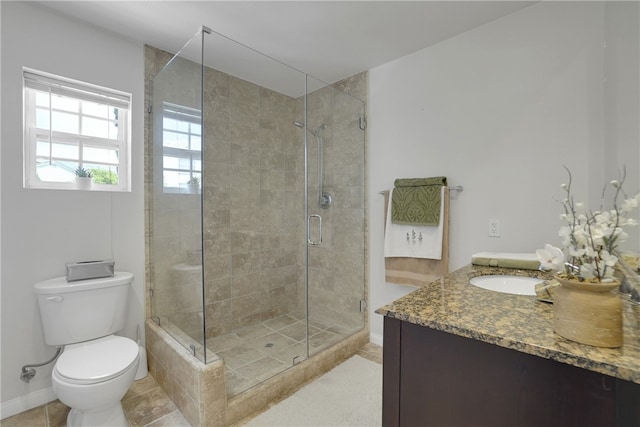 bathroom featuring tile patterned floors, vanity, toilet, and a shower with shower door