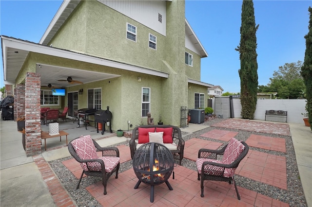 rear view of property featuring an outdoor living space with a fire pit, ceiling fan, cooling unit, and a patio