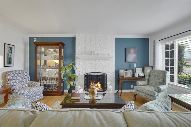 living room featuring plenty of natural light, light wood-type flooring, ornamental molding, and a brick fireplace