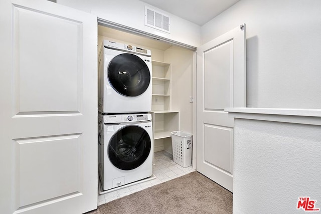 washroom featuring light colored carpet and stacked washing maching and dryer