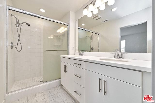 bathroom featuring tile patterned floors, vanity, and a shower with door