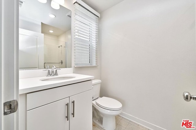 bathroom with tile patterned flooring, vanity, an enclosed shower, and toilet