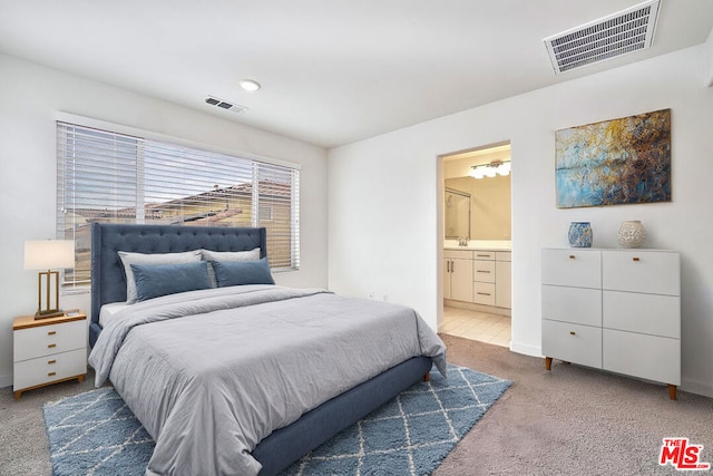 bedroom featuring carpet floors, ensuite bathroom, and sink