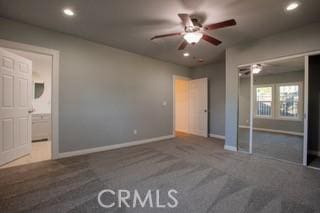 unfurnished bedroom with dark carpet, a closet, and ceiling fan