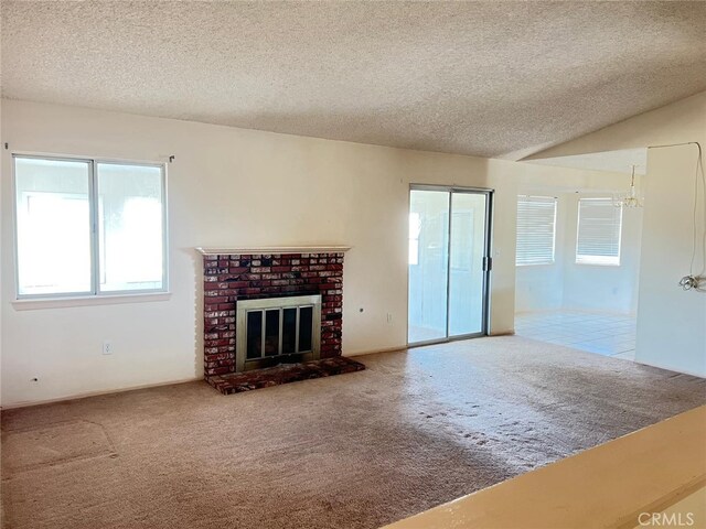 living room with a brick fireplace, a textured ceiling, carpet, and vaulted ceiling