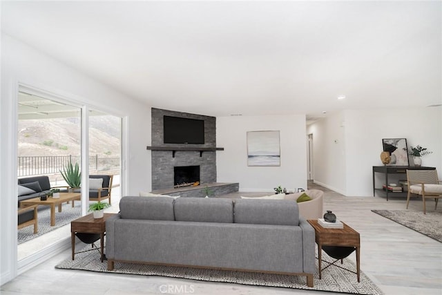 living room featuring light hardwood / wood-style flooring and a tiled fireplace