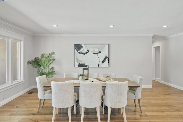 dining room with ornamental molding, a healthy amount of sunlight, and light hardwood / wood-style floors