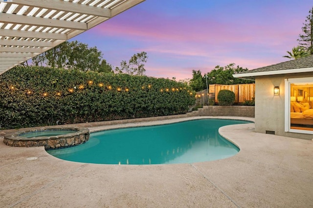 pool at dusk with a pergola, a patio area, and an in ground hot tub