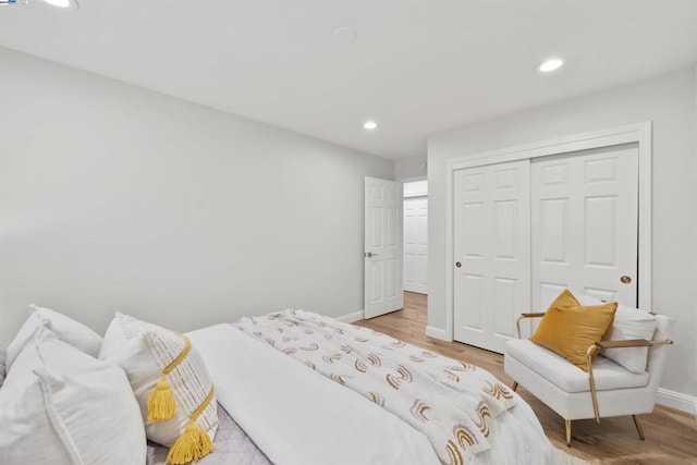 bedroom with light hardwood / wood-style floors and a closet