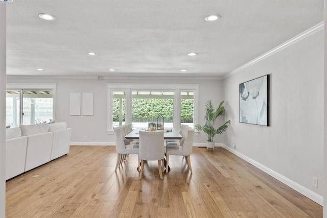 dining area with light wood-type flooring and ornamental molding