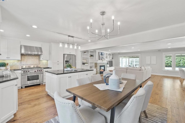 dining room with ornamental molding, light hardwood / wood-style flooring, and a notable chandelier