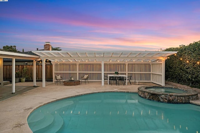 pool at dusk with an in ground hot tub, a pergola, a fire pit, and a patio