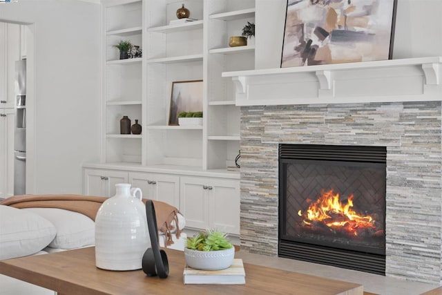 details with built in shelves, stainless steel fridge, and a tile fireplace