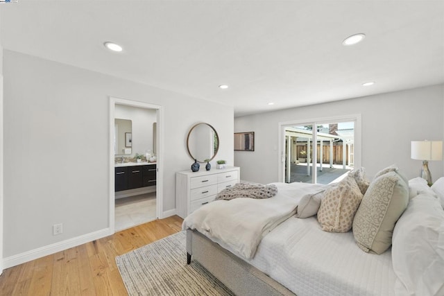 bedroom with ensuite bath, access to outside, sink, and light hardwood / wood-style floors