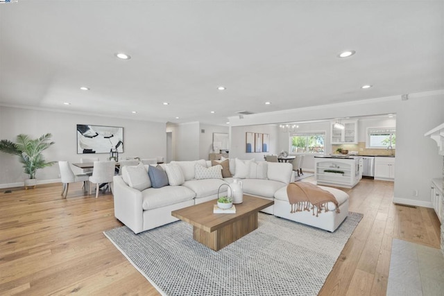 living room featuring light wood-type flooring and crown molding