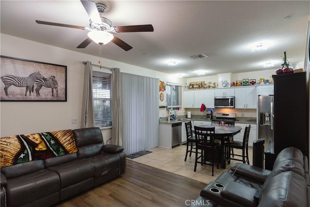 living room featuring ceiling fan and light hardwood / wood-style flooring