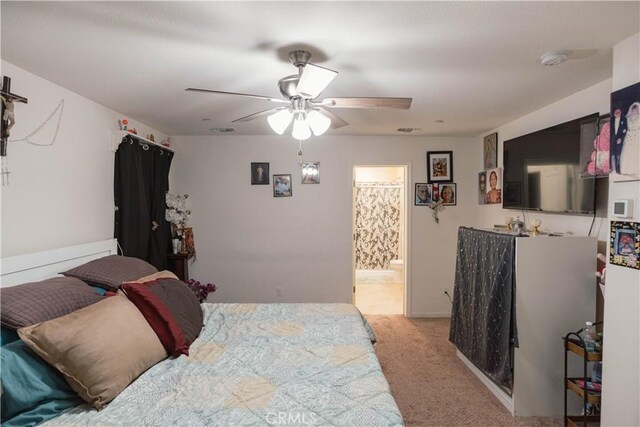 carpeted bedroom featuring ceiling fan and ensuite bath