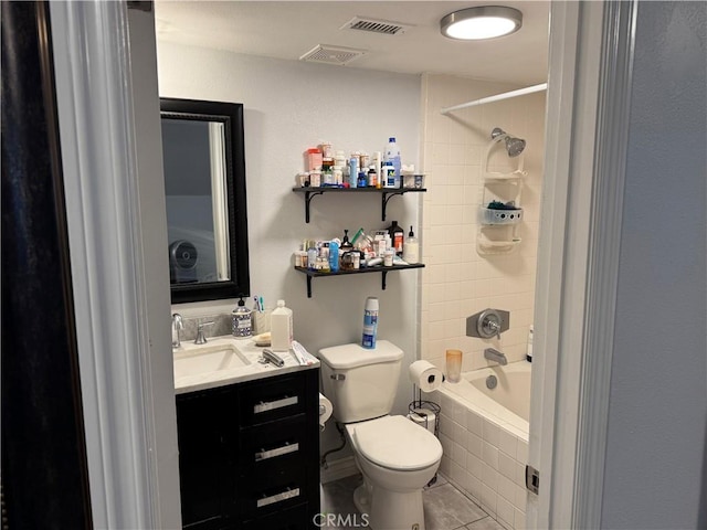 full bathroom featuring toilet, vanity, tiled shower / bath, and tile patterned flooring