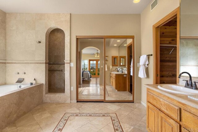 bathroom with tiled bath and vanity