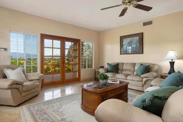 living room featuring ceiling fan, a healthy amount of sunlight, and french doors