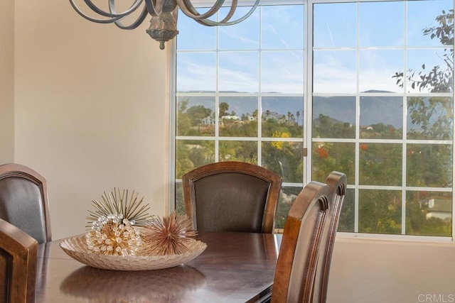 sunroom with a mountain view and a chandelier