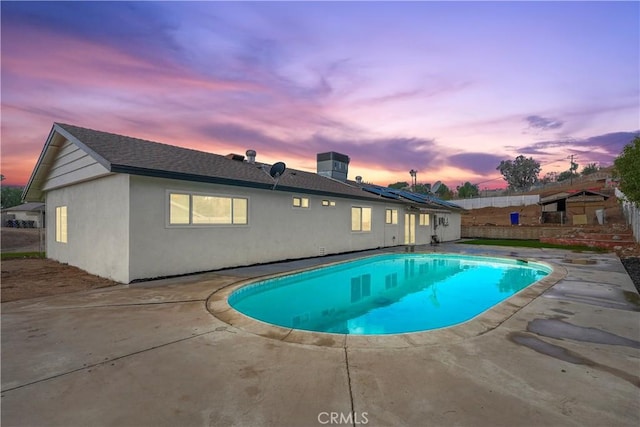 pool at dusk with a patio