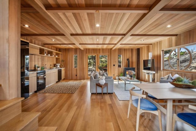 living room featuring wooden ceiling, beam ceiling, light hardwood / wood-style flooring, and wooden walls