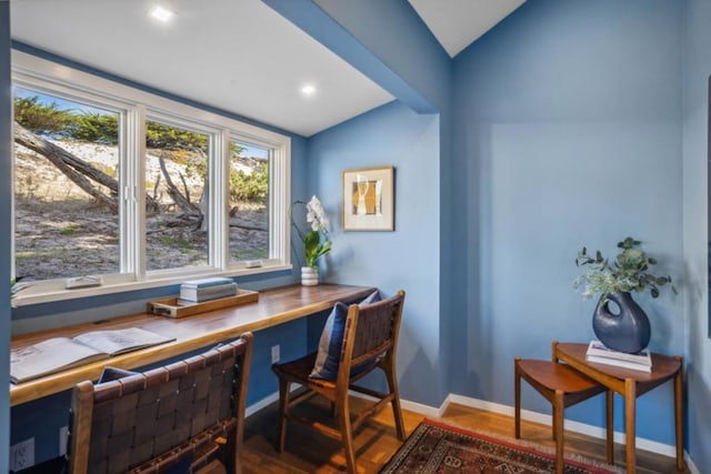 home office with vaulted ceiling and hardwood / wood-style floors