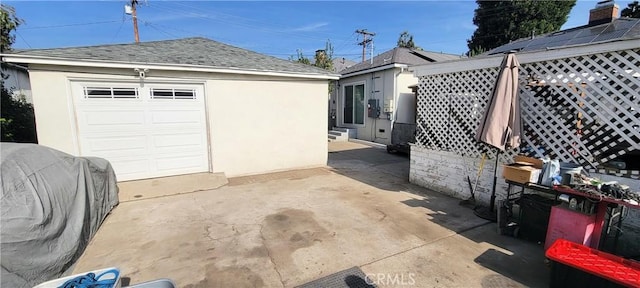 view of patio featuring a garage and an outbuilding