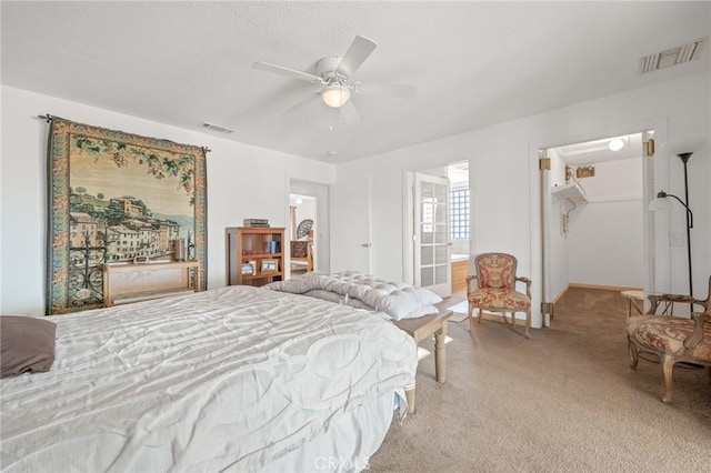 carpeted bedroom with ceiling fan, a walk in closet, connected bathroom, and a closet