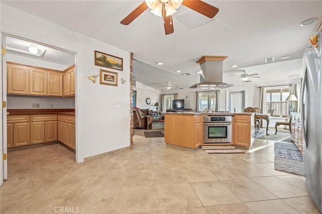 kitchen with kitchen peninsula, stainless steel appliances, island range hood, light brown cabinets, and lofted ceiling