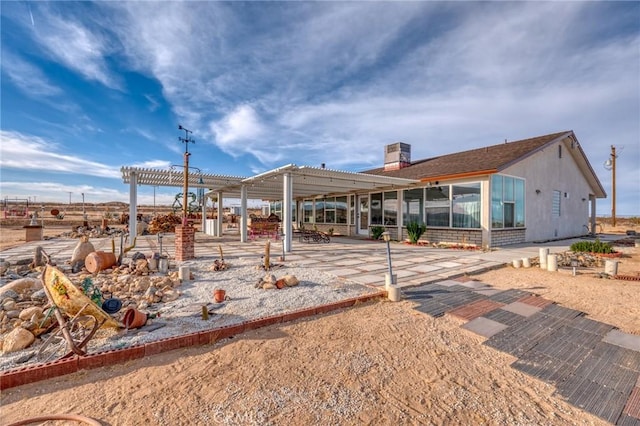 rear view of property featuring a pergola and a sunroom