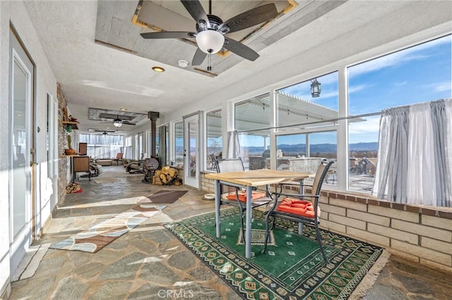 sunroom / solarium with a mountain view and ceiling fan