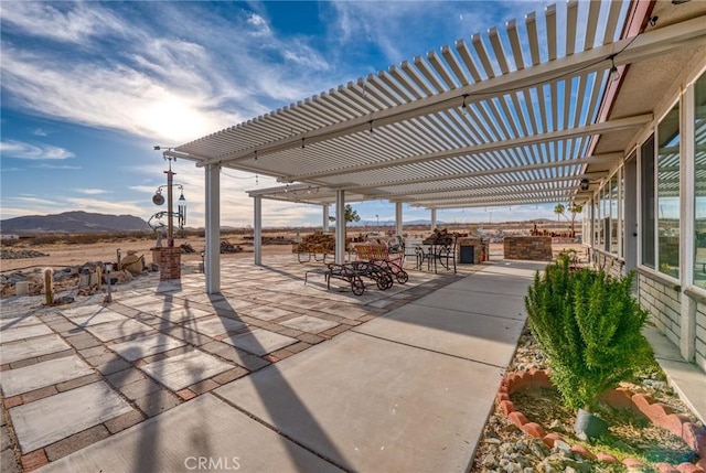 view of patio / terrace with a pergola, area for grilling, and a mountain view